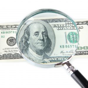 magnifying glass over $100 bill